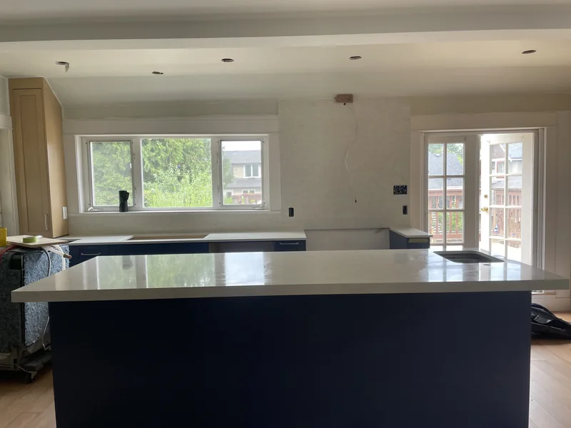 Light island countertop with navy cabinetry