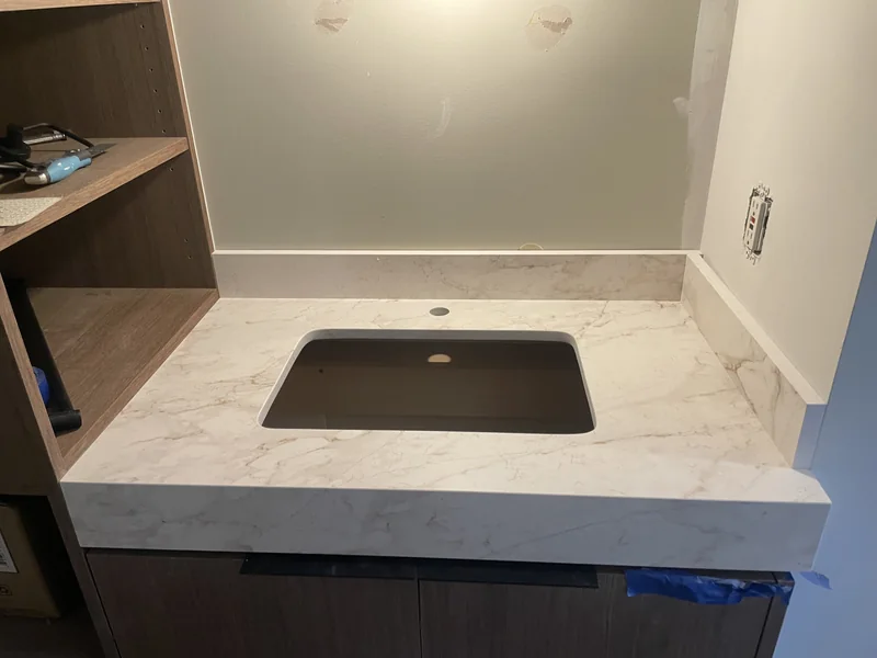 Compact vanity surface with a matching backsplash