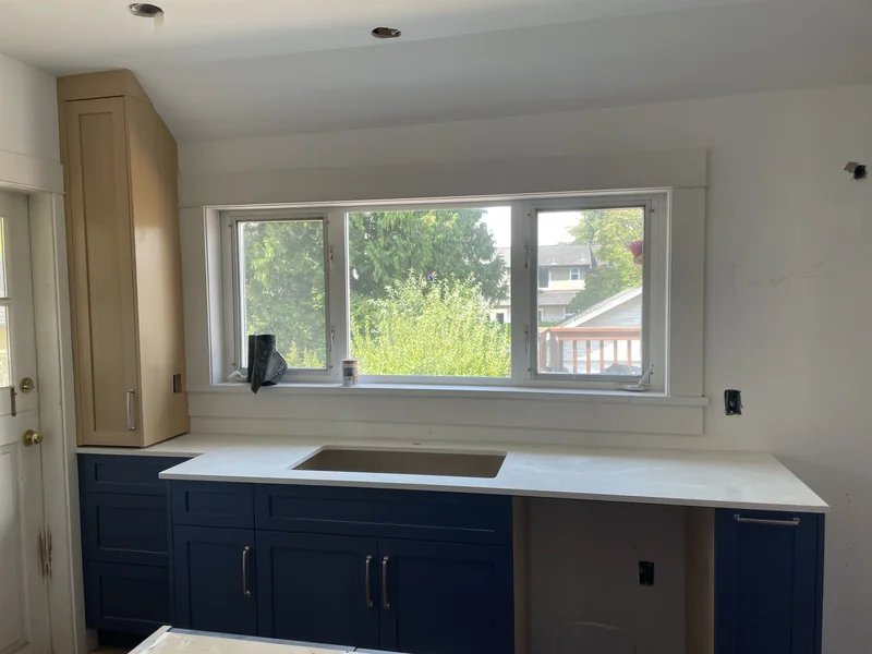 Window-side kitchen counter with navy cabinets