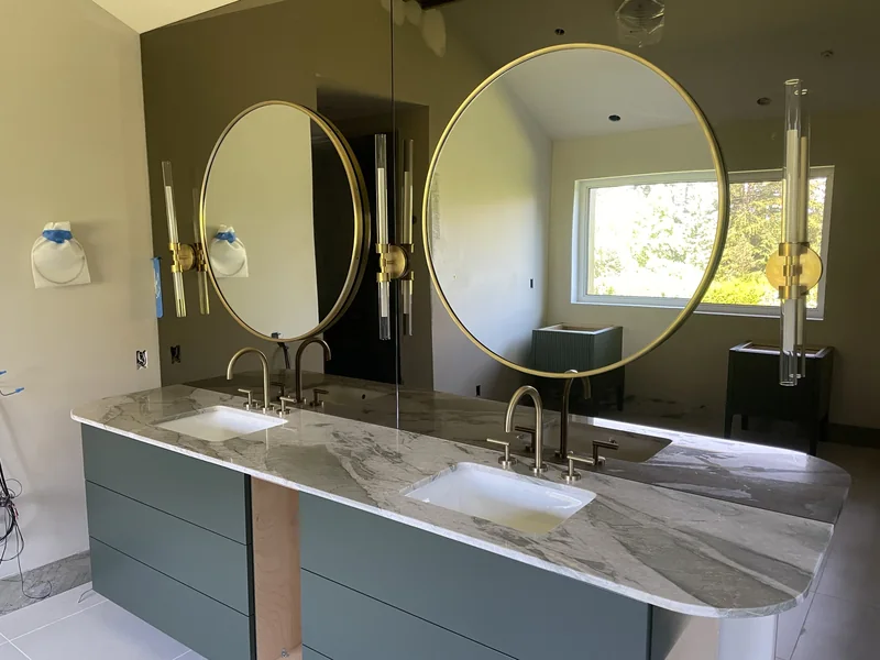 Rounded double vanity with green-and-white veining