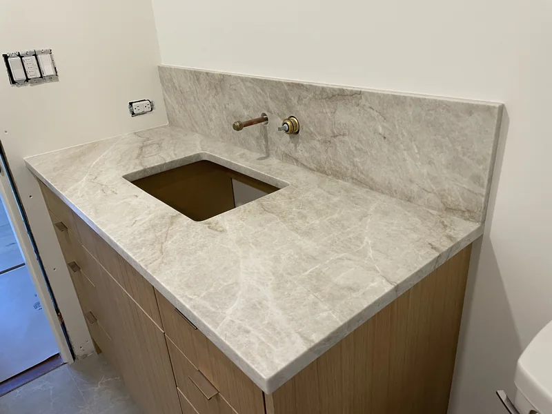 Warm-toned vanity and tall matching backsplash