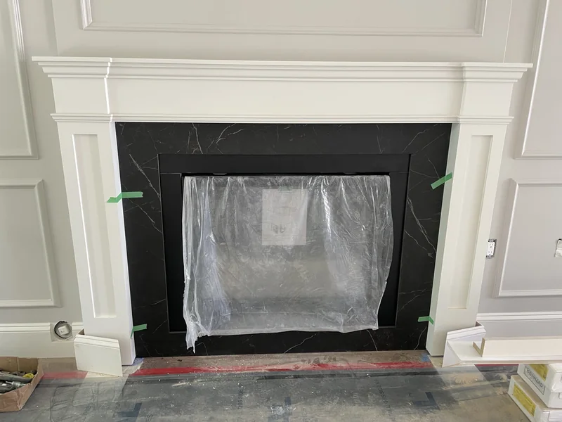 Dark veined fireplace surround within white mouldings